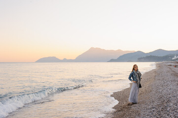 Serene Sunset Over Coastal Beach With Woman Enjoying The Scenic View