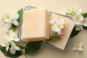 Soap bars and jasmine flowers on beige background, flat lay