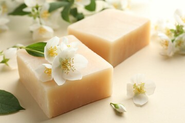 Soap bars and jasmine flowers on beige background, closeup