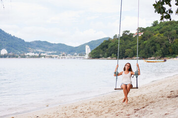 Tranquil Scene of a Young Woman Relaxing on a Swing at the Beach