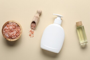Flat lay composition with bottle of liquid soap, sea salt and essential oil on beige background