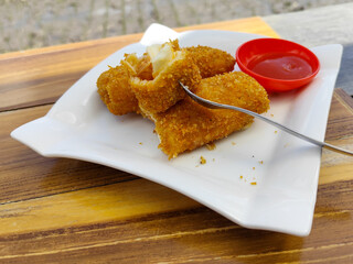Crispy golden rissoles with savory and delicious filling, served on an elegant white plate,...