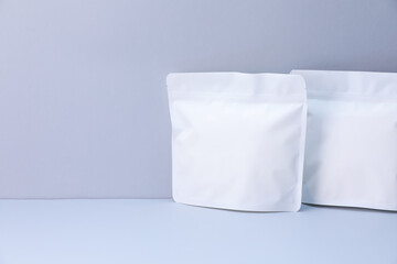 Two zipper stand-up pouches on light grey background. Mockup for design