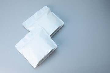 Two zipper stand-up pouches on light grey background, above view. Mockup for design