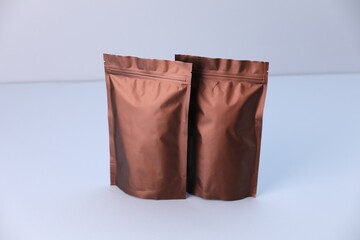 Two zipper stand-up pouches on light grey background. Mockup for design