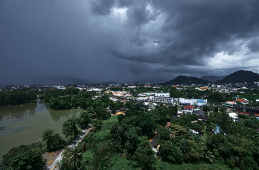 Stormy Sky Over a Vibrant City Landscape Amidst Lush Greenery