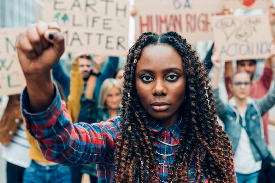 Young activist raising fist at protest for human rights and climate change