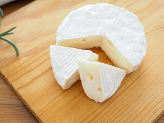  カッティングボードの上の切り分けたカマンベールチーズ
