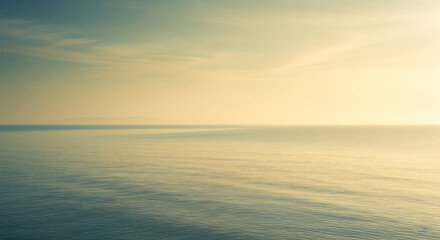 Fototapeta premium A calm and peaceful ocean stretches to the horizon under a soft, light sky