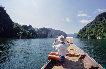 Woman Sailing through Idyllic Mountain Lake with Scenic Views on a Sunny Day
