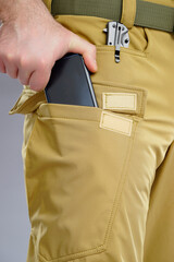 Man Storing Smartphone in Durable Pocket with Tactical Belt and Knife Holder