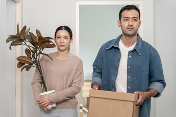 Moving house, Husband and wife hold box and furniture for new apartment or home, inside the room...