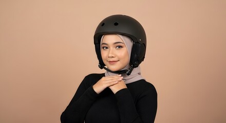 Young Woman Wearing Black Helmet and Hijab Smiling Confidently Against Neutral Background