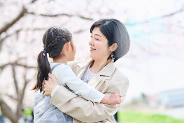 春の公園で抱き合う親子