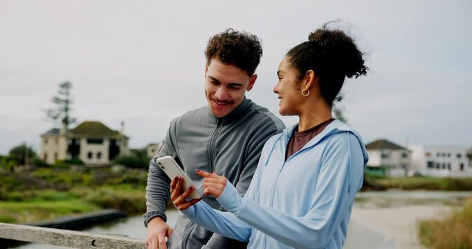 Fitness, workout and couple with phone outdoor for training, social media post or goal performance. People, discussion and tracking app on bridge for runner, partnership and cardio or exercise break