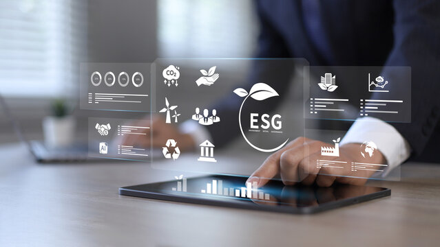 Businessman pressing button on tablet screen with ESG for Environment, Social and Governance in sustainable and ethical business operations.