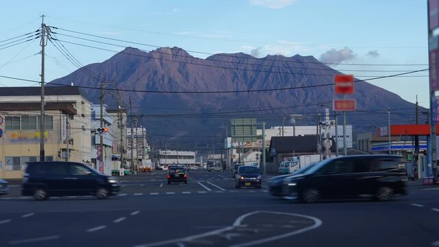 As the sunset casts its warm hues, the streets at the base of massive Sakurajima Volcano pulse with non-stop traffic, remaining as bustling as always.