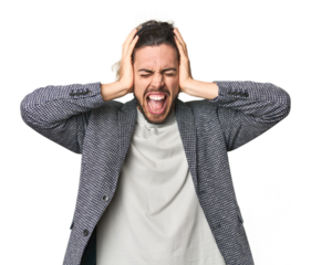 Young businessman in casual blazer covering ears with hands trying not to hear too loud sound.