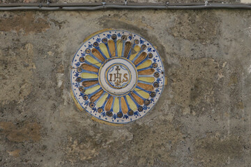 ceramic tile with the letters IHS : Iota Eta Sigma or Jesus Hominum Salvator