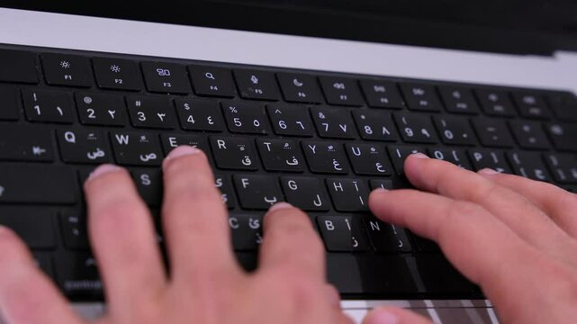 Fingers typing on bilingual Arabic-English keyboard in sharp detail, perfect for tech, education, or localization projects.