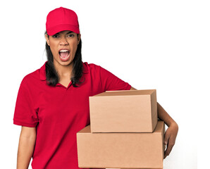 Young Filipina courier with two packages screaming very angry and aggressive.