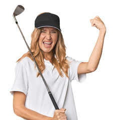 Young blonde golfer in studio raising fist after a victory, winner concept.