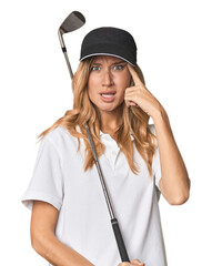 Young blonde golfer in studio showing a disappointment gesture with forefinger.