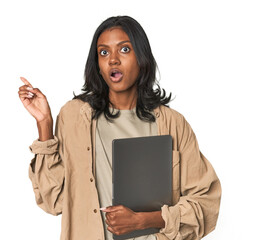 Young Indian woman studying with laptop pointing to the side
