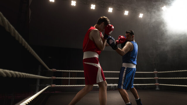 Two boxers confront each other in 3D ring illuminated by dramatic lighting and enveloped in smoke effects. Concept of intense competition and sportsmanship.