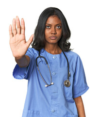 Young Indian nurse with stethoscope standing with outstretched hand showing stop sign, preventing...