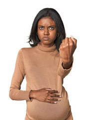 Young Indian pregnant woman showing fist to camera, aggressive facial expression.