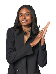 Young Indian woman in business suit feeling energetic and comfortable, rubbing hands confident.