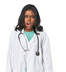Young Indian doctor with stethoscope shouting very angry, rage concept, frustrated.