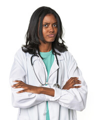 Young Indian doctor with stethoscope suspicious, uncertain, examining you.