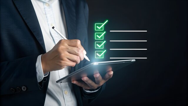 Person holding tablet checking off green ticks on digital checklist mark done