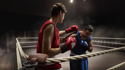 A boxing match is underway in a dimly lit 3D ring, with two fighters displaying focused, intense...