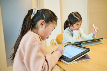 タブレットを使う二人の少女