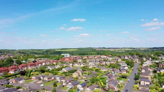 Aerial footage of the town of Batley the market town in the Kirklees district in Leeds West Yorkshire England showing a drone view of a typical British housing estate from above in the summer time