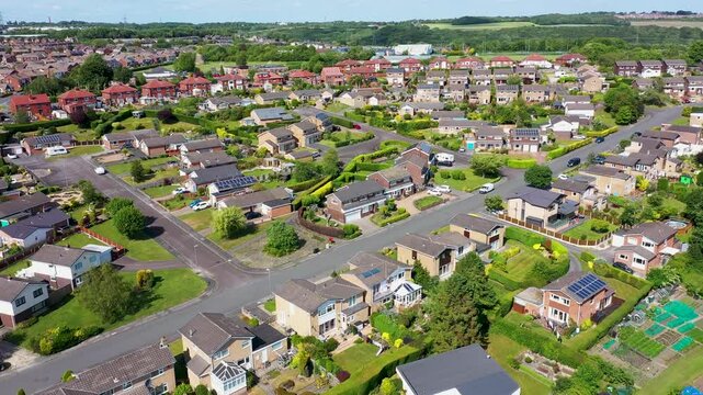 Aerial footage of the town of Batley the market town in the Kirklees district in Leeds West Yorkshire England showing a drone view of a typical British housing estate from above in the summer time
