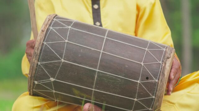 A traditional percussionist plays Indonesian ethnic music. A musician plays a traditional Indonesian musical instrument known as a kendang or gendang