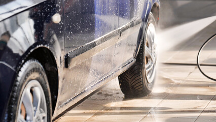 Water spraying car side during car wash in service station