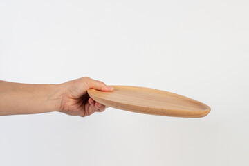 Oval wooden plate in hand on white background