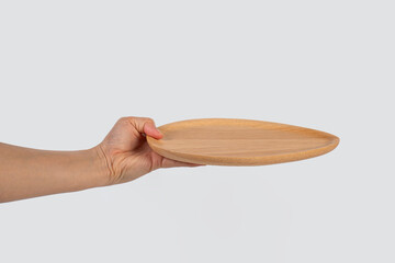 Oval wooden plate in hand on white background