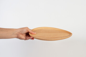 Oval wooden plate in hand on white background