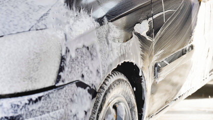 Car wash with active foam dripping on black car