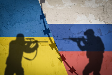Conceptual image of war between Russia and Ukraine with shadow of soldier against wall with flags