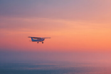 light aircraft soaring gracefully against stunning sunset over ocean