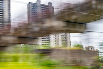 Dynamic motion blur view from high-speed train window: Green landscape, trees & fields rush past at high speed