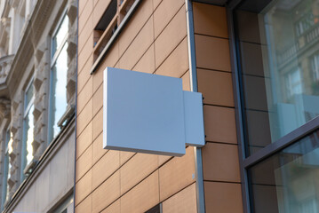 Modern blue square signage mounted on sleek facade, perfect for contemporary store branding, tech...