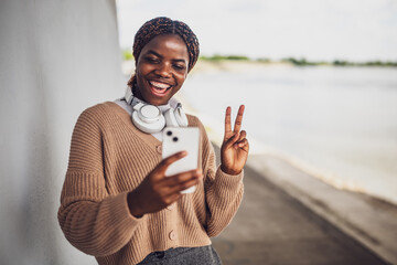Portrait of young black woman who is having video call on smartphone.